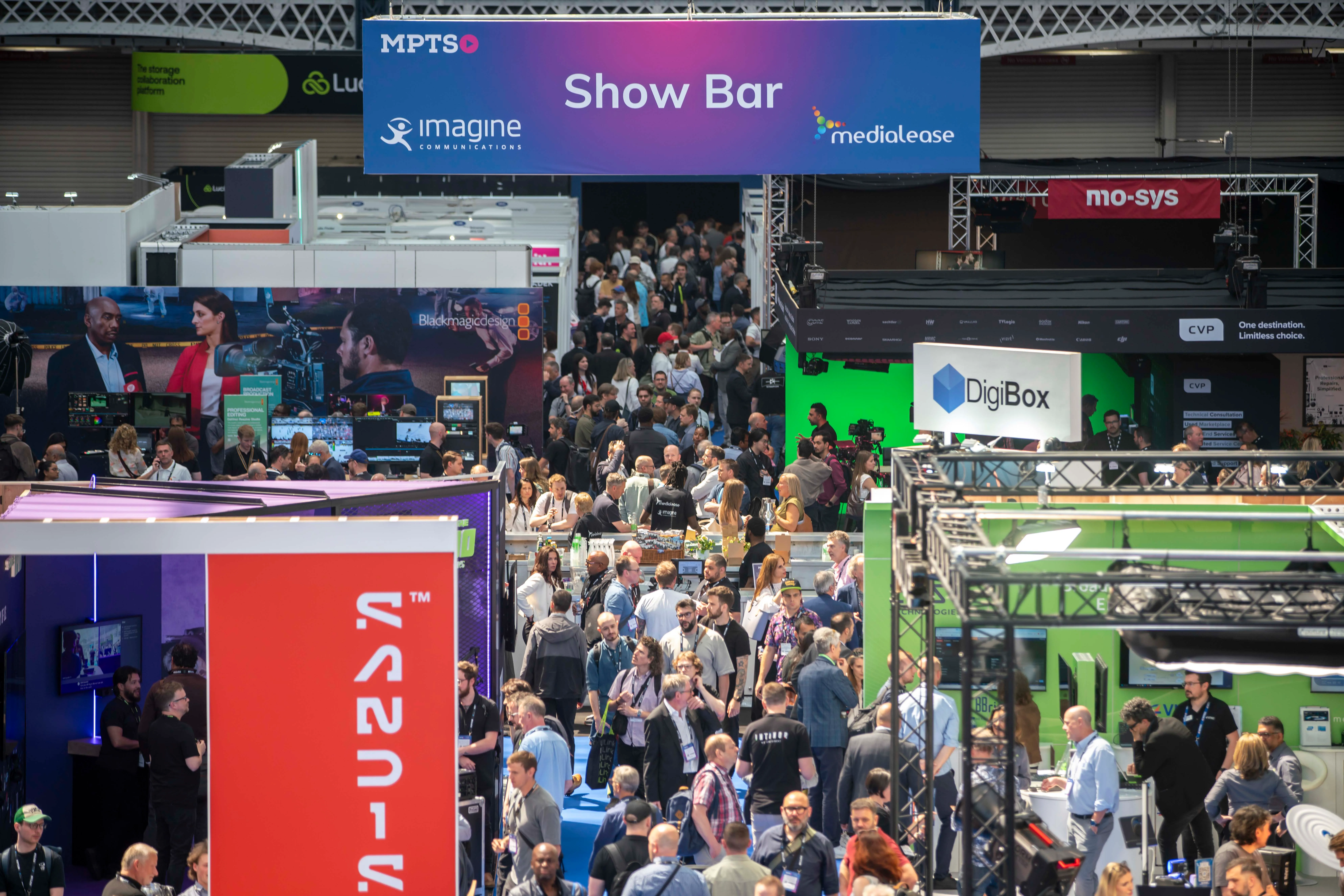 A bustling scene at the MPTS 2026 event show bar, featuring a vibrant crowd and various industry stalls.